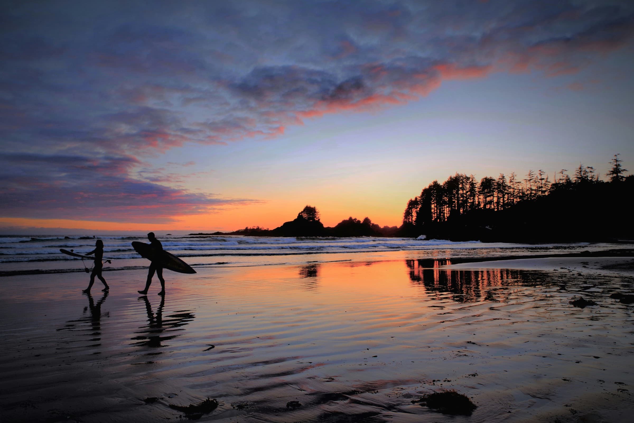 A surfer at sunset in Tofino, BC